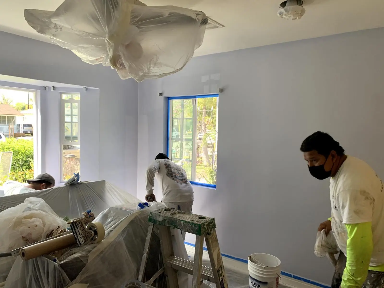Johnny's crew painting a bedroom with furniture fully covered