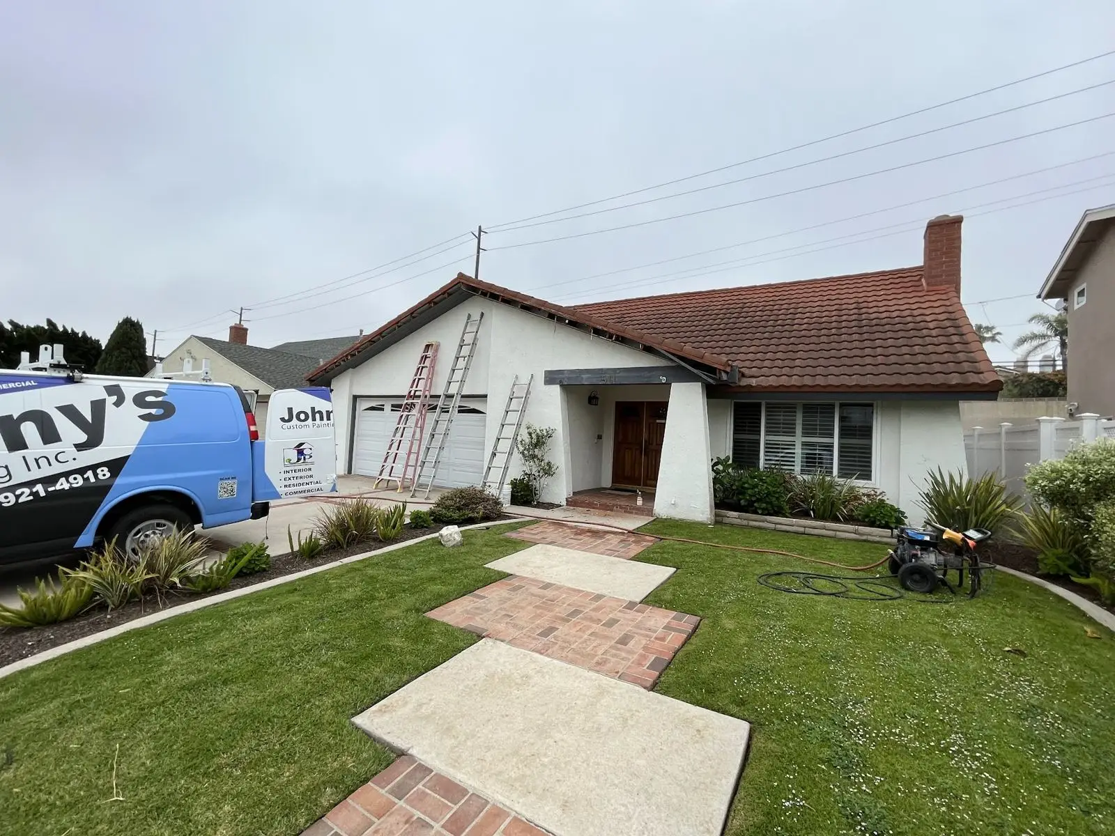Same ranch home before painting with faded walls and red trim
