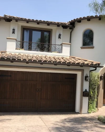 Spanish-style home with stained wood garage door