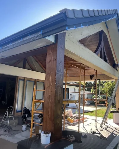 Covered patio with stained beams during painting