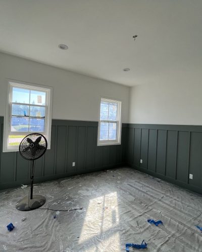 Bedroom with deep green board-and-batten wainscoting